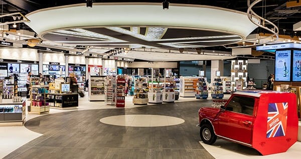 An airport travel retail store, with a red Mini painted in a Union Jack livery parked on the shop floor